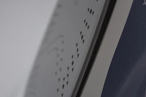 Gray white plastic iron with sprayer, metal bottom is on a white plastic. Stockfoto's