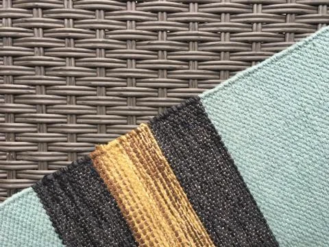 Gray wicker texture and woven multi-colored carpet. Stock Photos