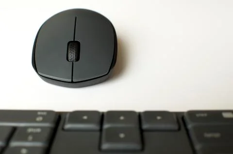 A gray wireless mouse and a keyboard Fotos de archivo