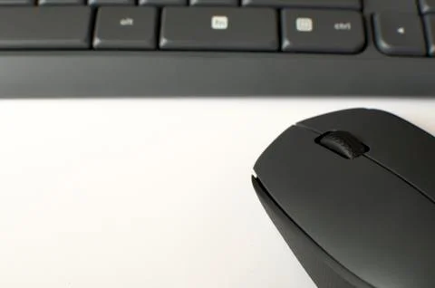 A gray wireless mouse and a keyboard Stock-Fotos