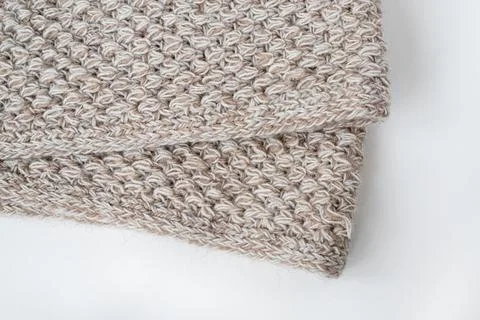 Gray wool knitted blanket. The edge of a beige crochet blanket on a white bac Stock Photos