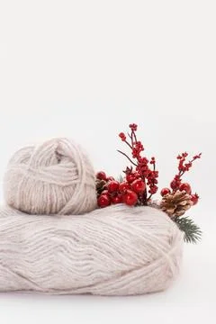 Gray wool skeins or wool yarn with branch of red berries and pine cones Stock Photos