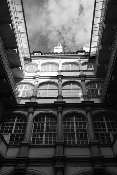 Grayscale low angle of a facade of a building with arch pattern glass windows un Stock Photos