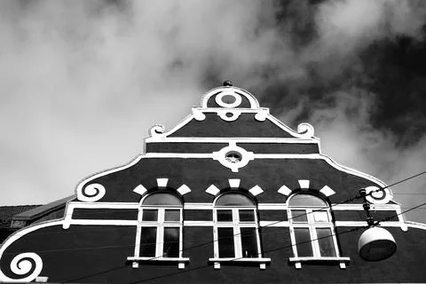 Grayscale low angle of a triangle shape house roof against a cloudy sky Stock Photos