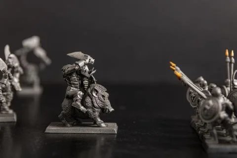 A grayscale selective focus shot of a creature figurine near Sparta soldiers  Stock Photos