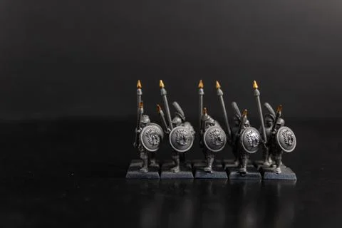 A grayscale selective focus shot of a group of Sparta soldiers holding spears Stock Photos