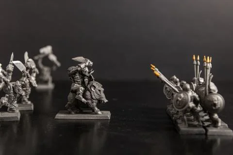 A grayscale selective focus shot of mythical creature attacking Sparta soldie Stock Photos
