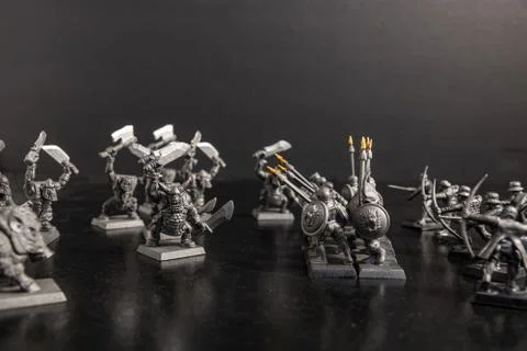 A grayscale selective focus shot of mythical creatures near soldiers with spe Stock Photos