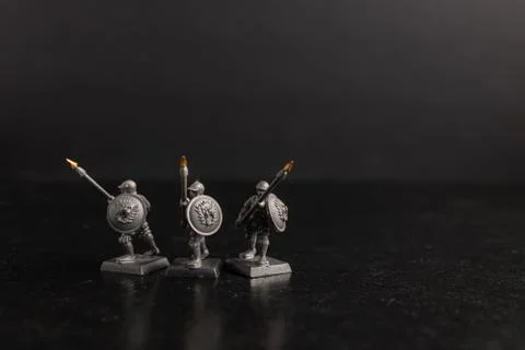 Grayscale selective focus shot of soldier holding spears figurines Foto stock