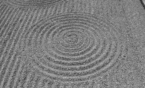 Grayscale shot of circle shape rock design in a rock garden in Kyoto temple Foto stock