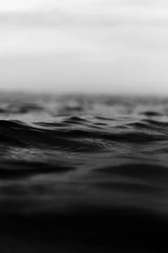 Grayscale vertical shot of tiny rough sea waves 스톡 사진