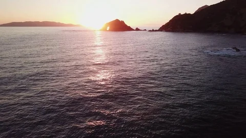 Grazing fligt over the sea at sunset with islands at distance Stock Footage 106541546