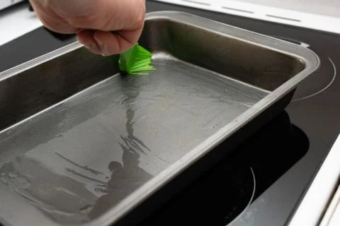 Greasing baking sheet with oil Stock Photos