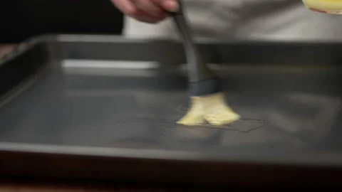 Greasing pan by silicone brush. Lubricating the Pan with melted butter. Stock Footage 135462651
