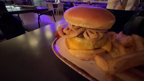 Greasy cheeseburger with crispy onions and bacon in restaurant Stock Footage 345260222
