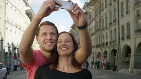 Great looking couple standing together and taking selfies in a beautiful Stock Footage 63023966
