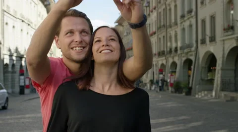 Great looking couple standing together and taking selfies in a beautiful Video stock 63024361