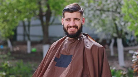 Great looking man with a large smile after a haircut in the garden outside he Stock Footage 136193347