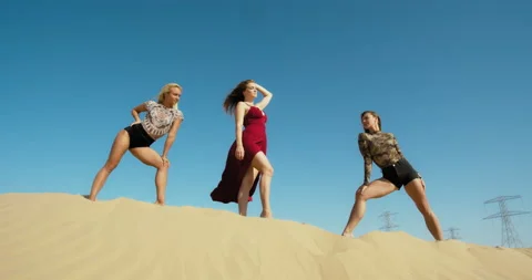 Great Sandy Desert of Dubai, three pretty women are posing on a sand dune, 4k Stock Footage 151518552
