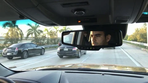 Great shot of man's face through rearview mirror as he drives Stock Footage 83250610