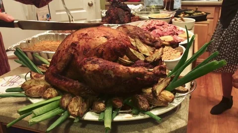 Great shot of a turkey being cut with other food around before a holiday dinner Stock Footage 83096699