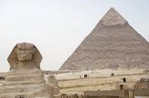 Great Sphinx on the background of the pyramid of Khafre. Cairo Stock Photos