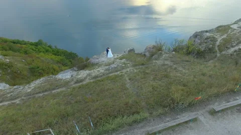 Great sunset on the lake between the mountains. A couple hugging at the edge of Stock Footage 87452952