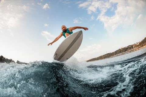 Great view of man on wakeboard while skilfully jumping over splashing river wave 스톡 사진