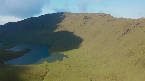 Greate caldera of Corvo volcano. Panoramic aerial shot of green slopes and lake Видео 117306355