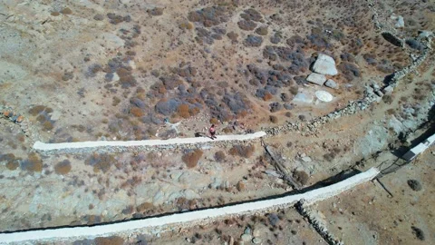 Greece Aerial active drone track man run through stones Tsagari Beach Mykonos 스톡 동영상 168201082