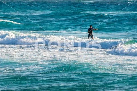Greece, Crete, August 2018: Young man, beginner Surfer learns to surf on a se Stock Photos