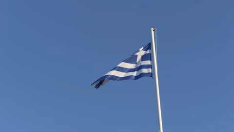 Greece flag waves gracefully under bright daylight, evoking seaside travel and Stock Footage 318293920