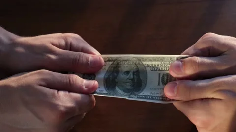 Greed concept. Two men can't share a hundred dollar bill Stock-Footage 136040292