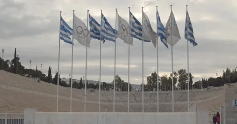 Greek and Olympic flags wave at the old olympic stadium Stock Footage 131972066