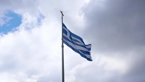 Greek Flag Blowing in Wind on Pole with Dramatic Clouds Low Angle Powerful .. Stock Footage 336515681