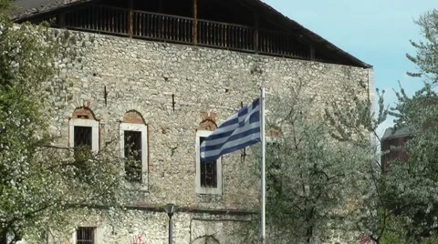 Greek flag waves in front of a building. Stockbeeldmateriaal 49131013