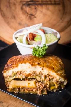 Greek Moussaka served with salad with garnish Stock Photos