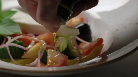 Greek salad with cucumbers, tomatoes, pepper, olives and cheese is dressed with Stock Footage