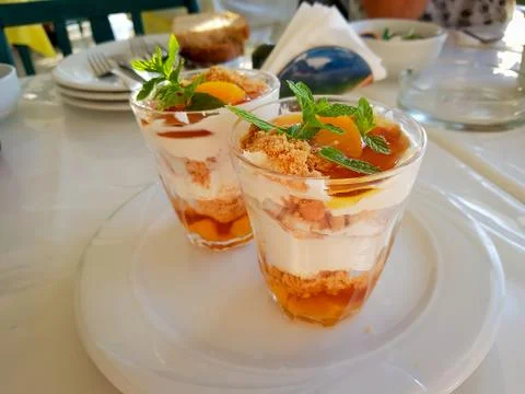 Greek yoghurt, apricot and honey with crumbled biscuits and mint Stock Photos