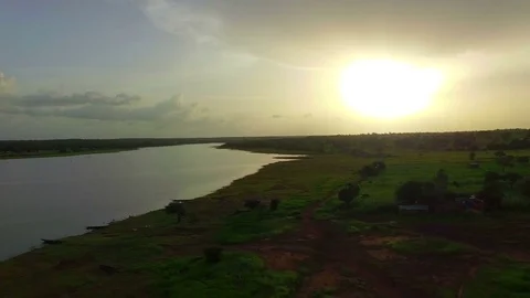 A green African plain of red earth near a river. Aerial video Stock Footage 71329641