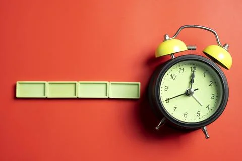 Green alarm clock with lime rectangular blocks on colored background. Empty.. Stock Photos