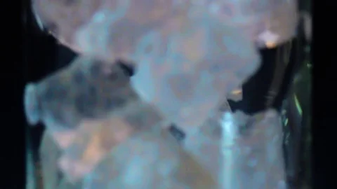 Green alcohol liquid pooring into capasity with ice Stock Footage 70772109