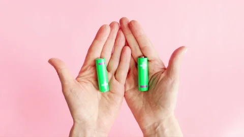 Green alkaline batteries AA type rechargeable accumulators in hand Stock Footage 235470911