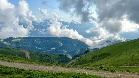 Green Alpine Slopes and Cloudy Mountains at Rosa Khutor Stock Photos