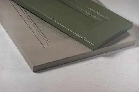 Green and gray kitchen facade lie on a white tested table Stock Photos