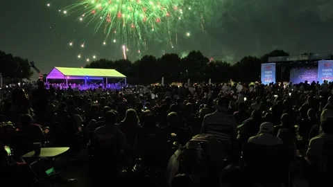 Green and multicolor fireworks exploding over a large crowd at night Stock-Footage 340941321