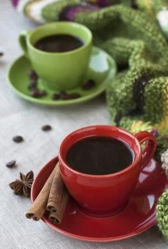 Green and red cups of coffee with coffee Bence, anise star and cinnamon Cho.. Stock Photos