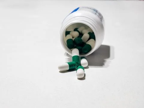 Green and White Capsules in the Bottle Stock Photos
