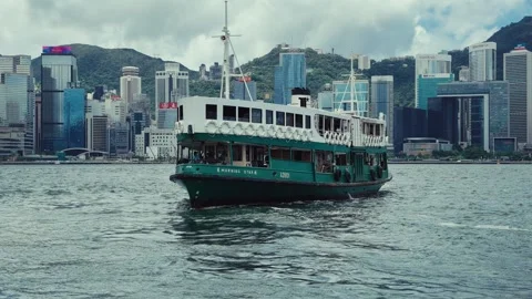 A green and white ferry navigates the waters of Hong Kong Harbor, gradually Stock Footage 338311014