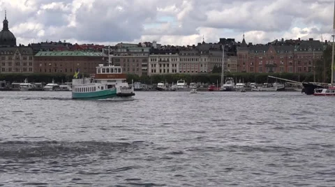 Green and white ferry sails from Norrmalm with historical ships at background Stock Footage 67384854